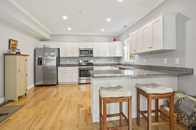 5 Mackenzie Way Unit 5, Haverhill, MA 01832 - kitchen featuring appliances with stainless steel finishes, a peninsula, recessed lighting, white cabinets, and crown molding