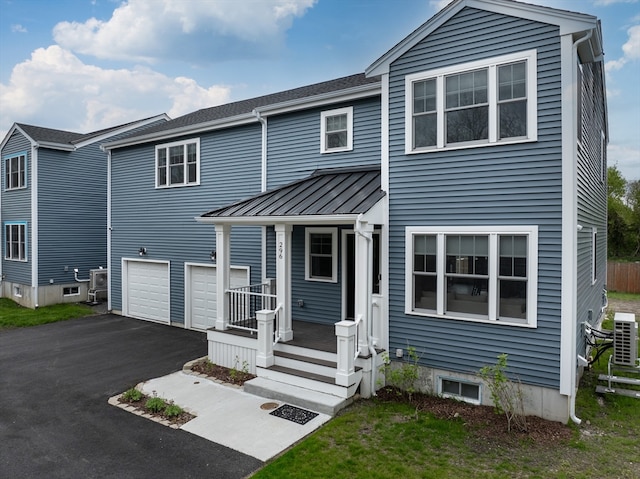 view of front of property with a garage and central AC unit