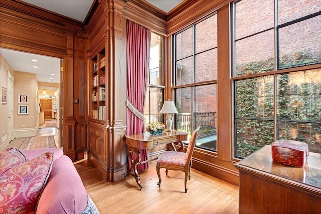 office with wood walls, light hardwood / wood-style flooring, and ornamental molding