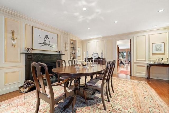 dining space with light wood-type flooring and ornamental molding