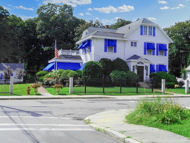 view of front of property with a fenced front yard, a front yard, and a chimney