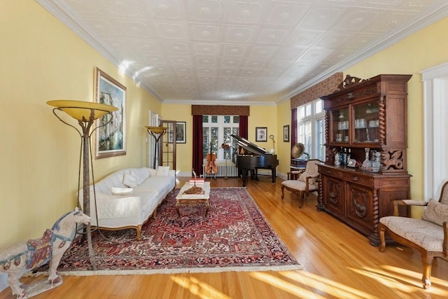 living area with ornamental molding and wood finished floors