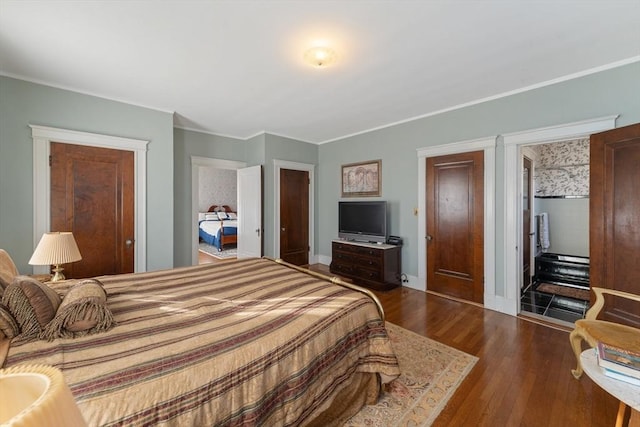 bedroom with baseboards, dark wood finished floors, and crown molding