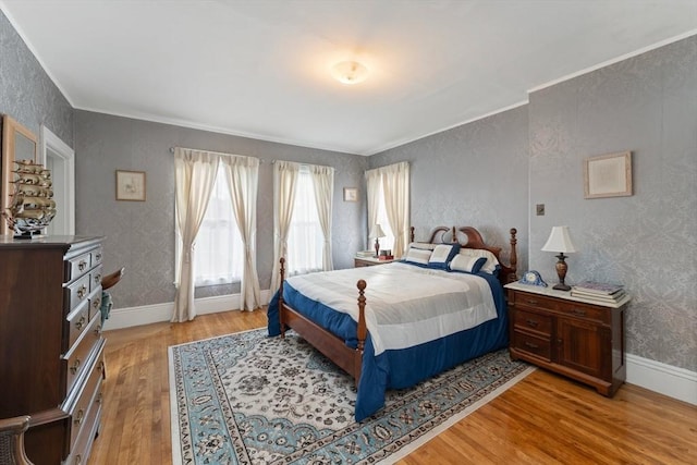 bedroom with ornamental molding, light wood finished floors, baseboards, and wallpapered walls