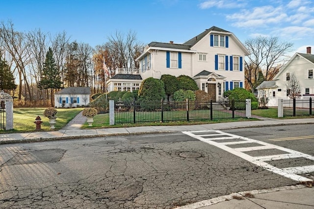 view of front of property with a fenced front yard, an outdoor structure, and a front yard