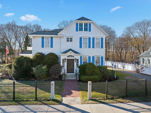 view of front facade with a fenced front yard and a front lawn