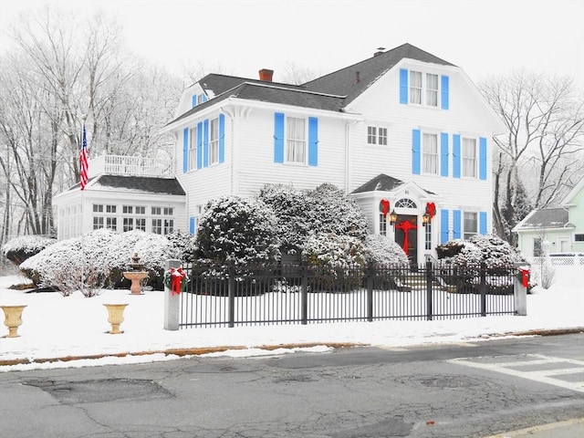 view of front of home with a fenced front yard and a chimney