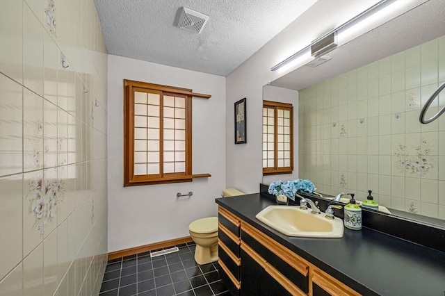 236 Williamsburg Dr, Longmeadow, MA 01106 - bathroom with toilet, vanity, tile patterned flooring, baseboards, and tile walls