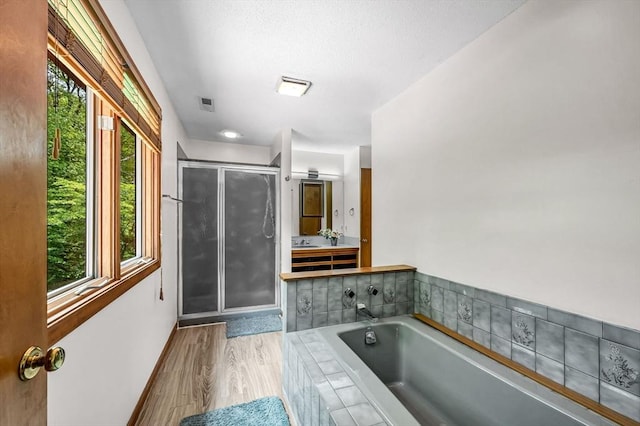 236 Williamsburg Dr, Longmeadow, MA 01106 - full bathroom featuring a stall shower, a garden tub, vanity, wood finished floors, and a textured ceiling