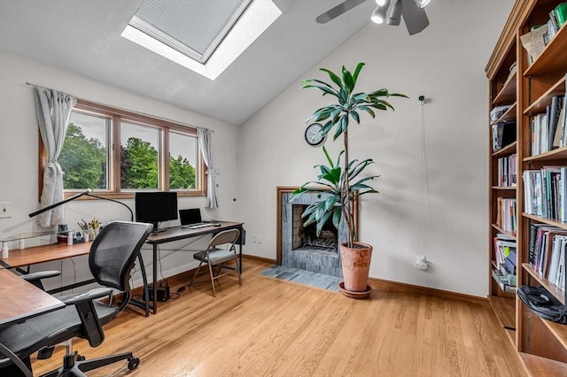 236 Williamsburg Dr, Longmeadow, MA 01106 - home office with baseboards, light wood-style floors, a tiled fireplace, vaulted ceiling, and a ceiling fan