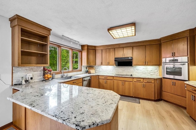 236 Williamsburg Dr, Longmeadow, MA 01106 - kitchen with stainless steel appliances, a sink, a peninsula, light wood-style floors, and brown cabinets