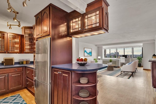 kitchen with kitchen peninsula, stainless steel refrigerator, and light hardwood / wood-style flooring