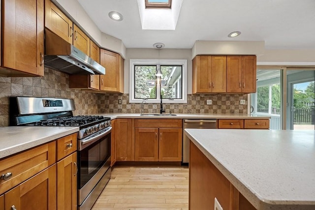 21 Nourse St, Westborough, MA 01581 - kitchen with stainless steel appliances, under cabinet range hood, a sink, light wood-type flooring, and light countertops