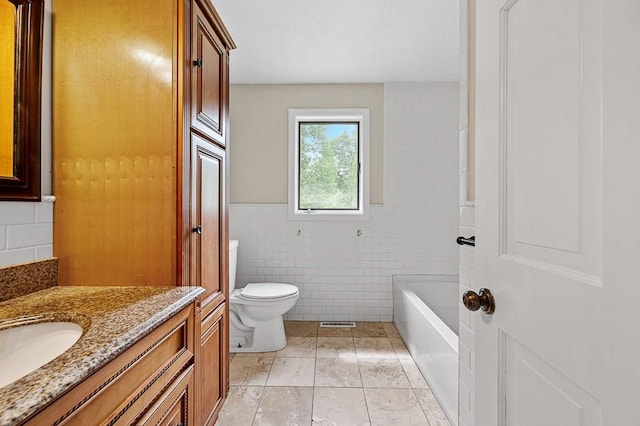 21 Nourse St, Westborough, MA 01581 - bathroom featuring vanity, toilet, tile walls, a bath, and tile patterned flooring