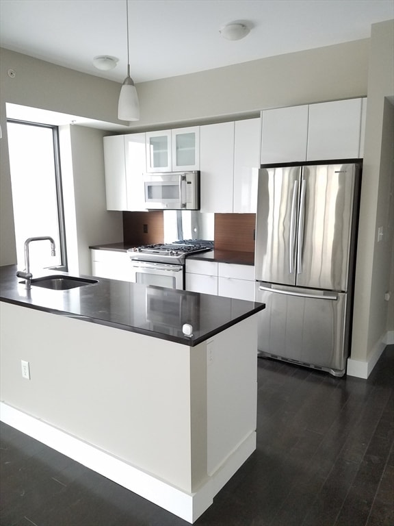 kitchen featuring appliances with stainless steel finishes, white cabinetry, pendant lighting, and sink