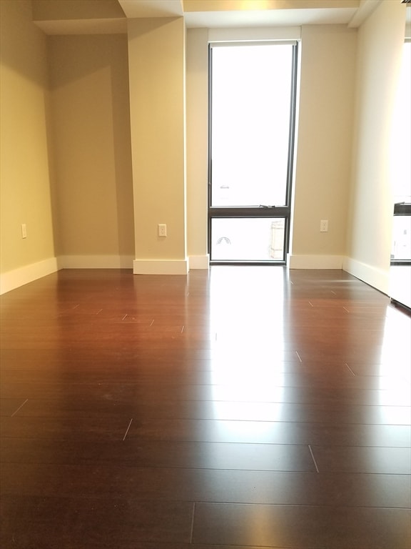 empty room with dark wood-type flooring