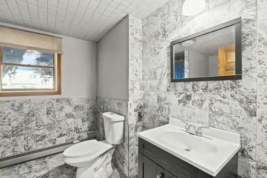 120 Hatchfield Dr, Brockton, MA 02301 - bathroom with baseboard heating, tile walls, vanity, and toilet