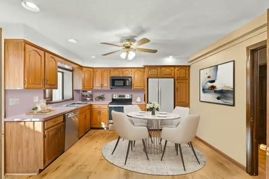120 Hatchfield Dr, Brockton, MA 02301 - kitchen featuring stainless steel appliances, light wood finished floors, light countertops, a ceiling fan, and brown cabinets