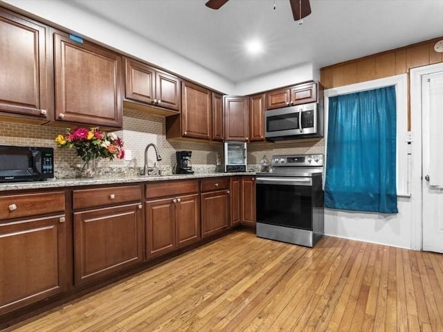 273 Elm St, Southbridge, MA 01550 - kitchen with appliances with stainless steel finishes, ceiling fan, backsplash, light wood-style flooring, and light stone countertops