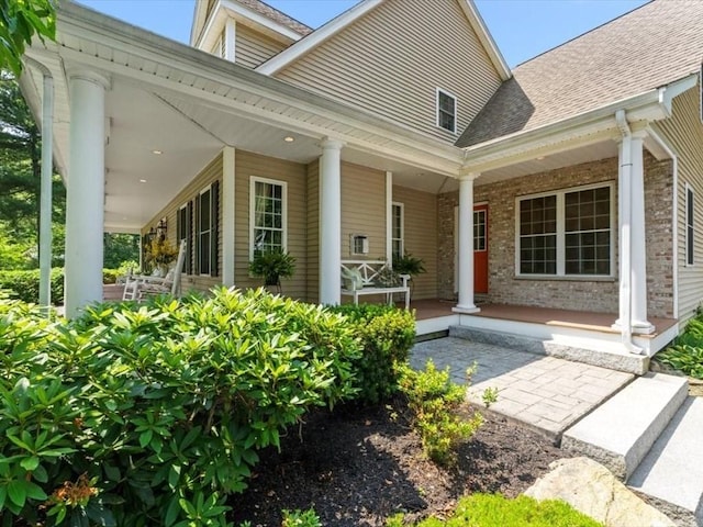 35 Oxbow Dr, Wrentham, MA 02093 - view of exterior entry featuring a porch, brick siding, and a shingled roof