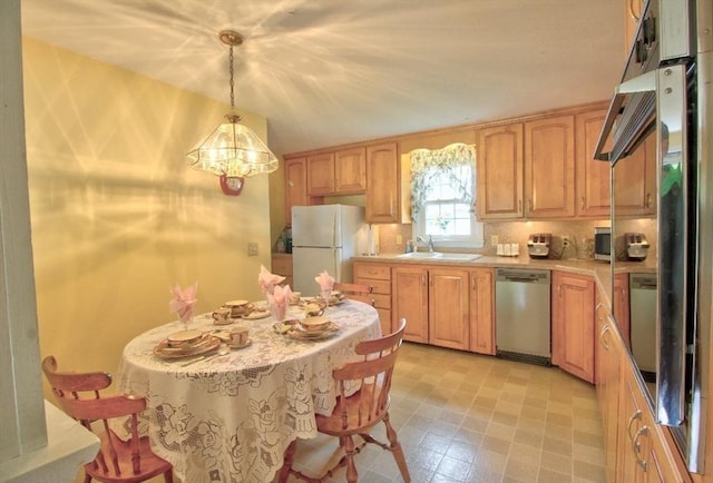 31 Lee Ave, Fitchburg, MA 01420 - kitchen with stainless steel dishwasher, freestanding refrigerator, a sink, a chandelier, and light countertops