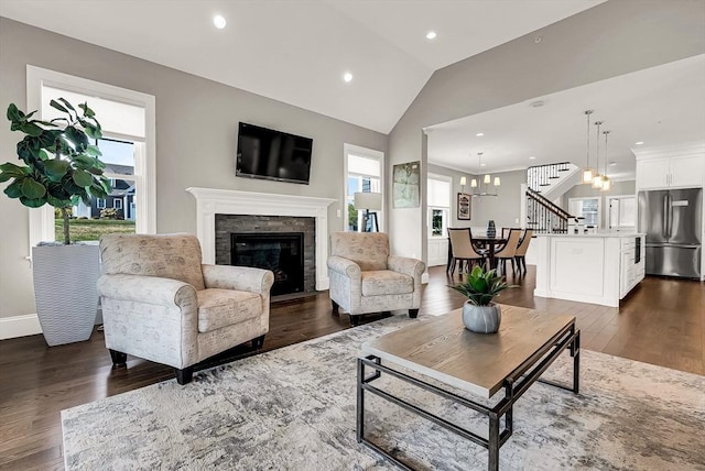 living room with dark hardwood / wood-style floors, vaulted ceiling, and a wealth of natural light