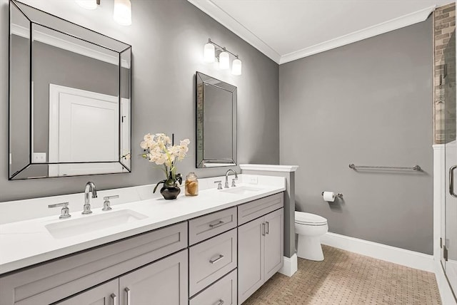 bathroom with vanity, toilet, a shower with shower door, and ornamental molding