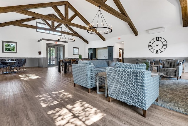 living room with an AC wall unit, hardwood / wood-style floors, high vaulted ceiling, and french doors