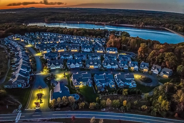 aerial view at dusk featuring a water view