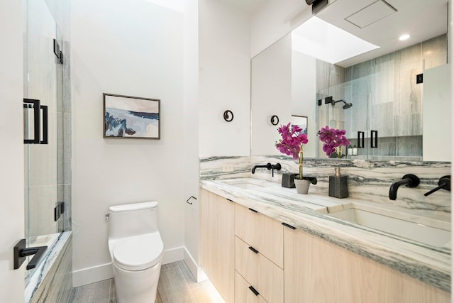 bathroom featuring vanity, toilet, a shower with shower door, and hardwood / wood-style floors