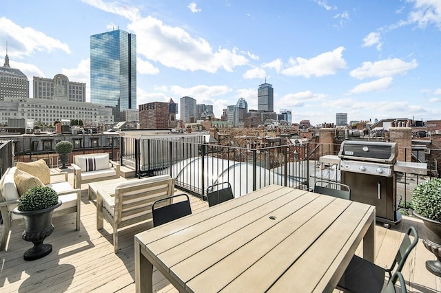 wooden deck with area for grilling and an outdoor hangout area