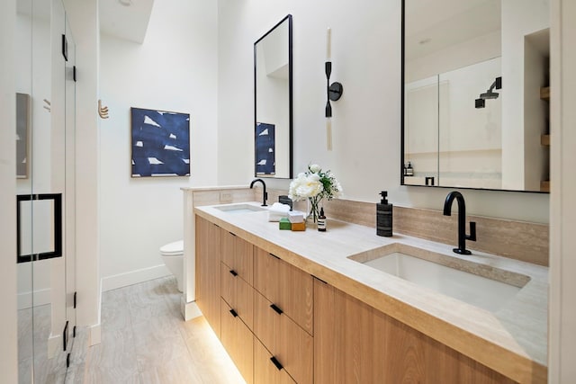 bathroom with vanity, toilet, and hardwood / wood-style floors