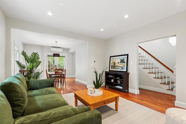 17 Perry St, Somerville, MA 02143 - living room featuring wood finished floors, stairs, recessed lighting, a wall unit AC, and french doors