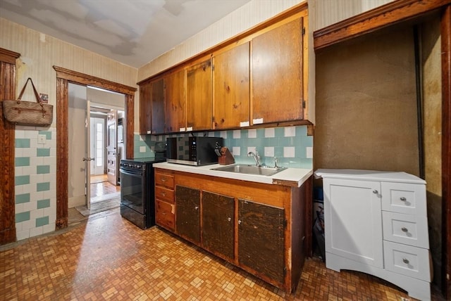 8 Ward St, Salem, MA 01970 - kitchen with black electric range, light countertops, brown cabinets, and tasteful backsplash