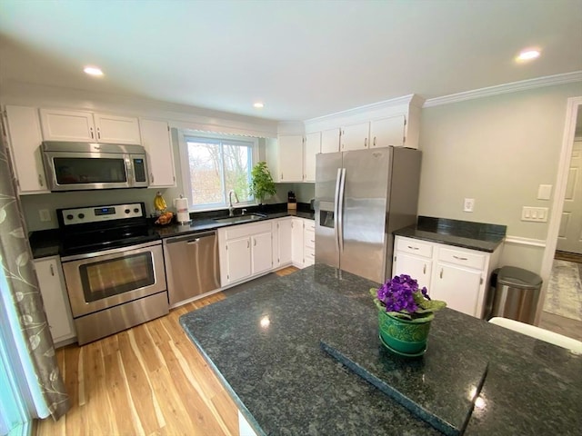 kitchen with white cabinets, light hardwood / wood-style floors, sink, and stainless steel appliances