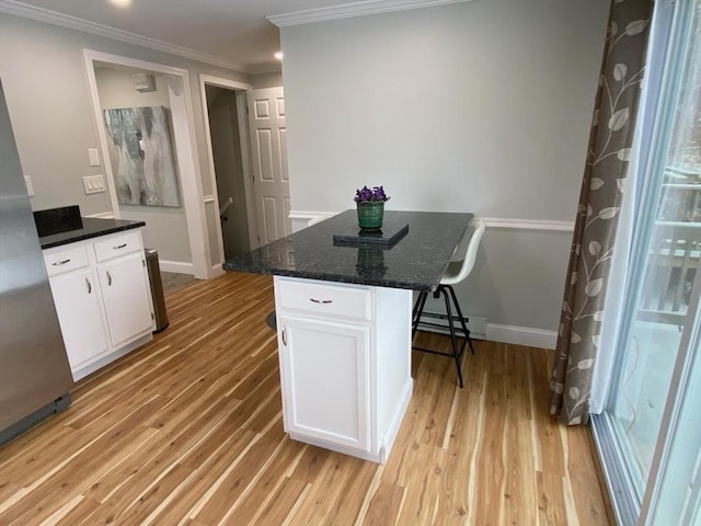 kitchen featuring light wood-type flooring, a center island, white cabinetry, and baseboard heating