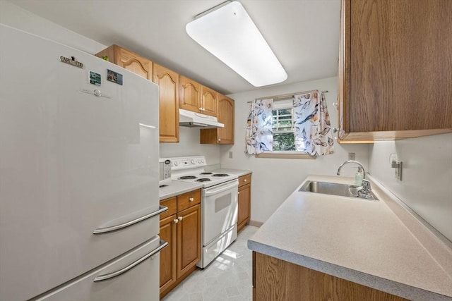 kitchen with a sink, light countertops, light floors, under cabinet range hood, and white appliances