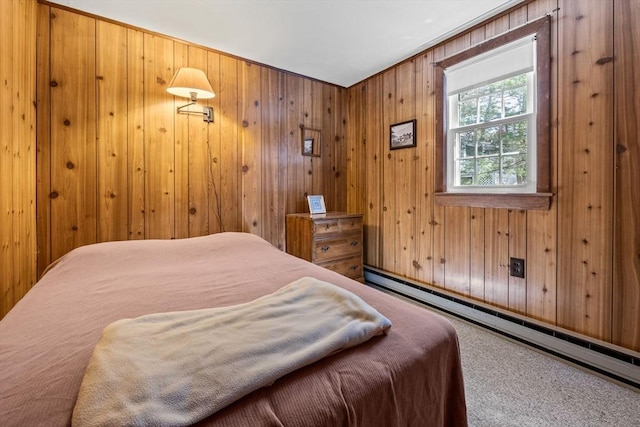 bedroom featuring wood walls, carpet, and a baseboard heating unit
