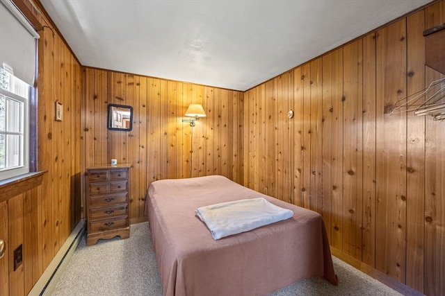 carpeted bedroom with wooden walls and a baseboard heating unit