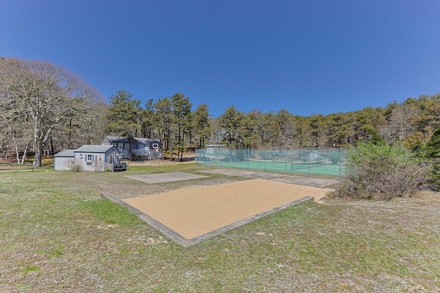 surrounding community featuring fence, a tennis court, and a yard