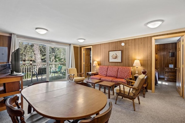 living room featuring wooden walls and light colored carpet