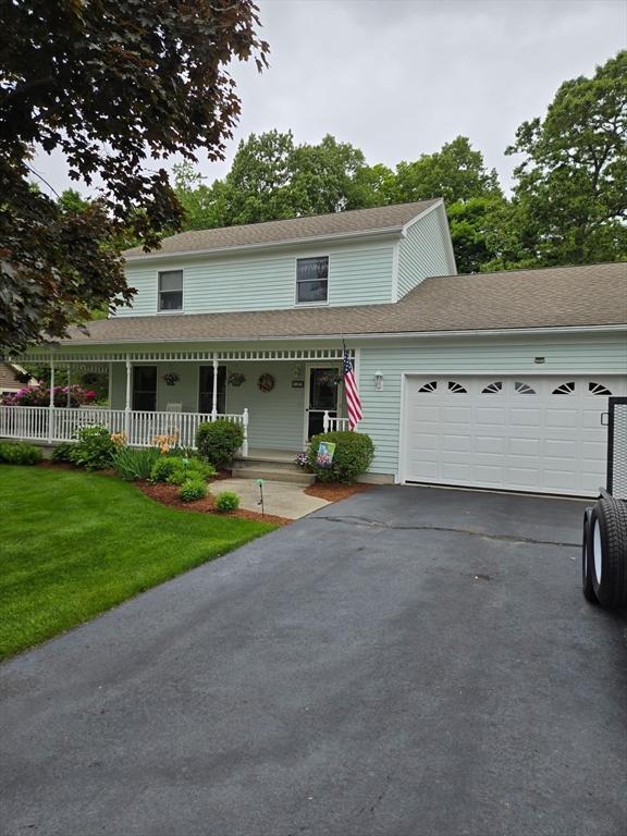 127 Parker Ln, Ludlow, MA 01056 - view of front facade with a garage, driveway, a porch, a front lawn, and a shingled roof