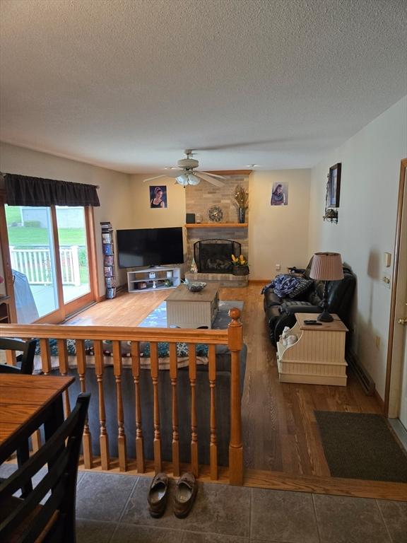 127 Parker Ln, Ludlow, MA 01056 - living room with ceiling fan, a textured ceiling, a fireplace, and wood finished floors