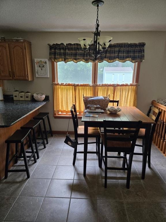 127 Parker Ln, Ludlow, MA 01056 - dining room with healthy amount of natural light, a chandelier, a textured ceiling, and dark tile patterned floors