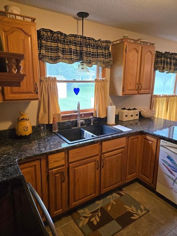 127 Parker Ln, Ludlow, MA 01056 - kitchen with a sink, a textured ceiling, dishwasher, tile patterned flooring, and brown cabinetry