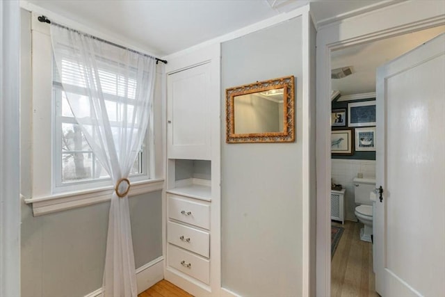 interior space featuring visible vents, toilet, tile walls, and wood finished floors