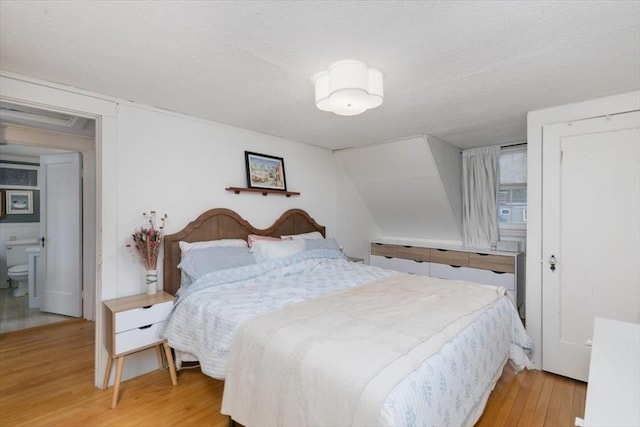 bedroom with light wood-type flooring and a textured ceiling