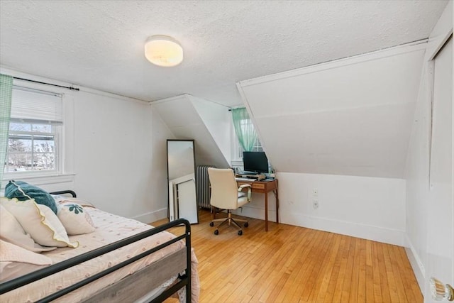 bedroom with light wood-style flooring, a textured ceiling, radiator, baseboards, and vaulted ceiling