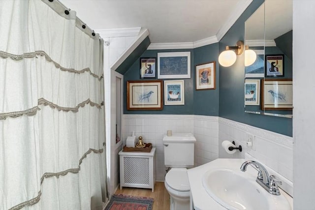 bathroom with a shower with curtain, wood finished floors, ornamental molding, a sink, and toilet