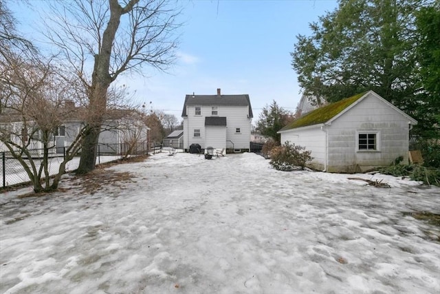 back of property featuring an outdoor structure and fence